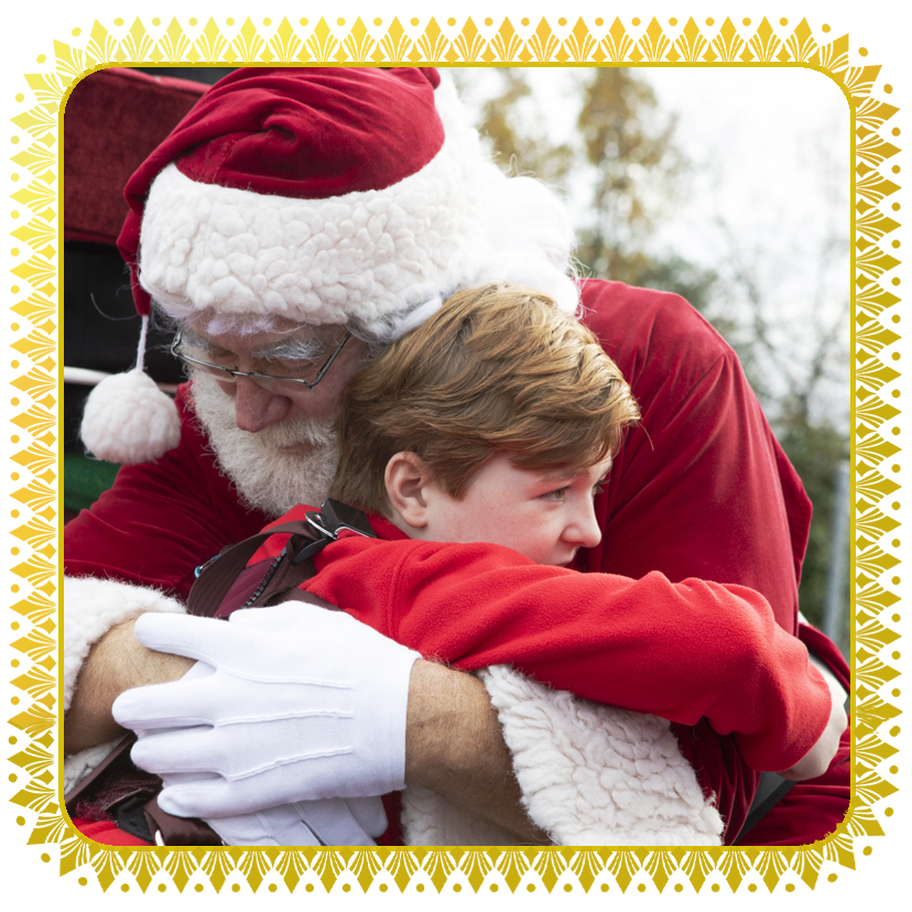 Santa hugging a very happy little boy / Papá Noel abrazando a un niño muy feliz